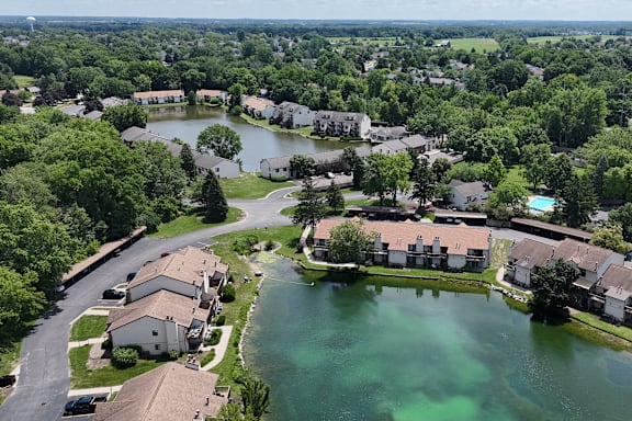 A bird's eye view of a residential area with a lake in the foreground.