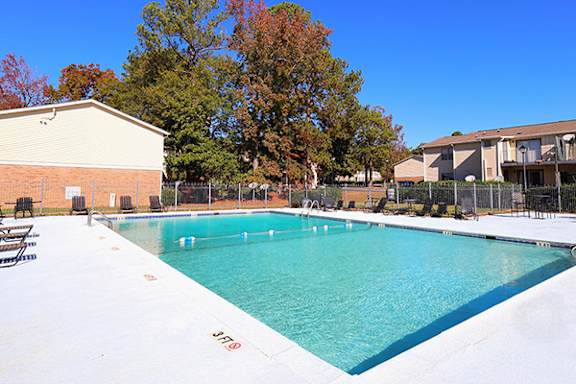 A large outdoor swimming pool with a building in the background.