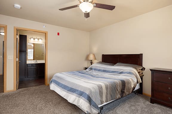 A bedroom with a bed, dresser, and mirror.