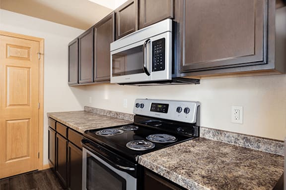 A kitchen with a stove top oven and microwave above it.