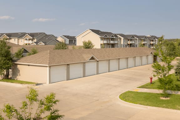 A fire hydrant is located on the grassy area of a residential complex.