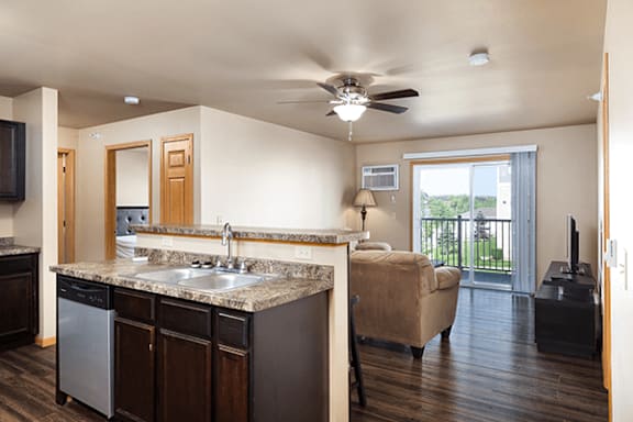 A kitchen with dark wood cabinets and a granite countertop.