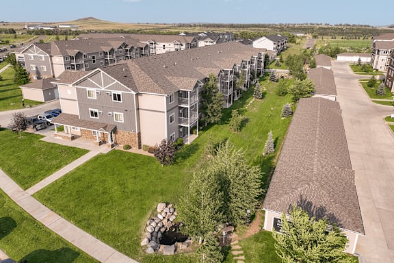 A large apartment complex with a green lawn in the foreground.