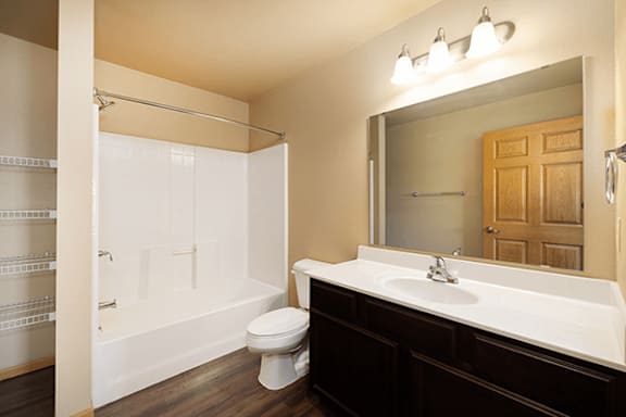 A white bathroom with a toilet, sink, and shower.
