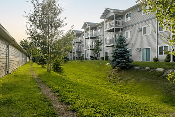 A grassy path leads to a building with balconies.