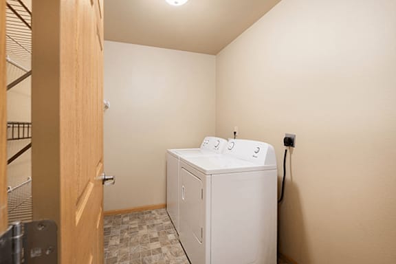 A white washing machine sits in a small laundry room.