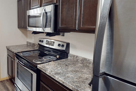 A kitchen with a stove top oven and microwave above it.