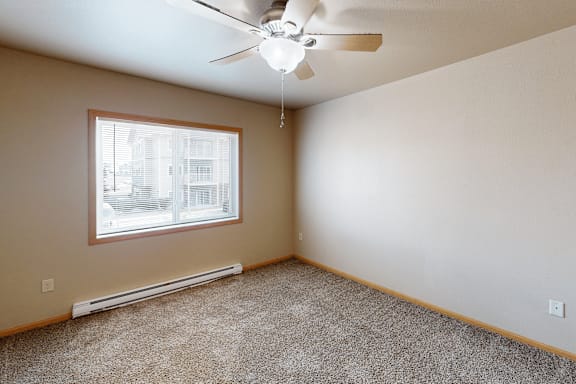 A room with a ceiling fan and a window.