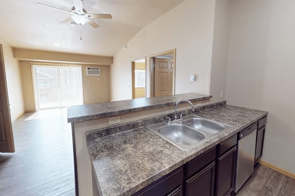 A kitchen with granite countertops and a ceiling fan.