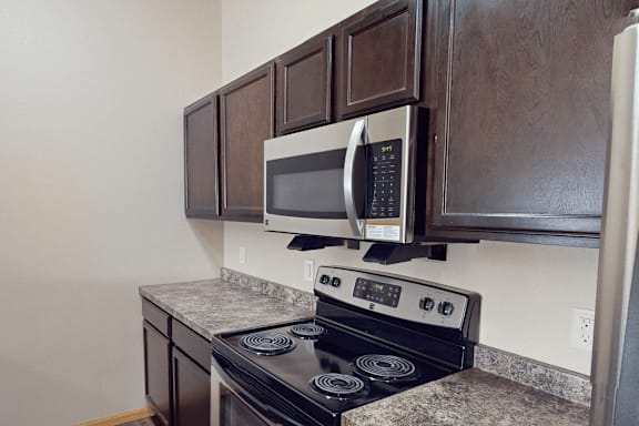 A black stove with a microwave on top of it.
