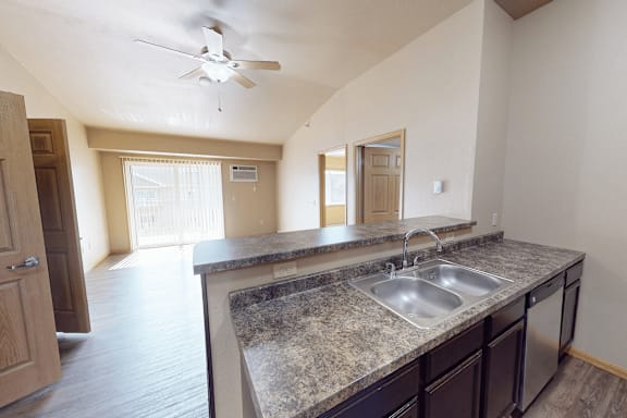 A kitchen with a sink and a fan.