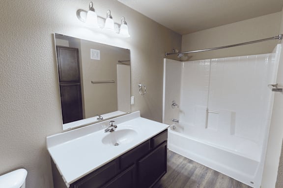 A bathroom with a white sink and a white toilet.