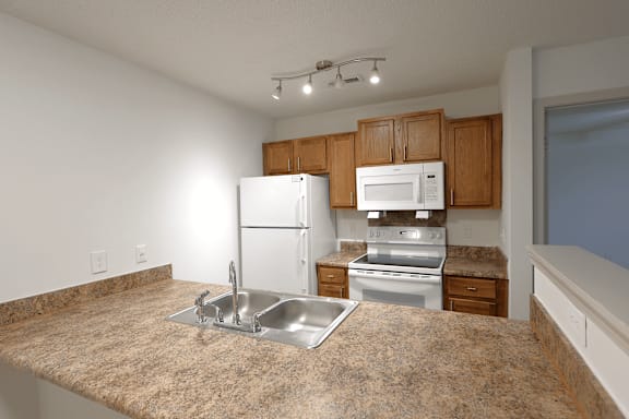 A kitchen with granite countertops and stainless steel appliances.
