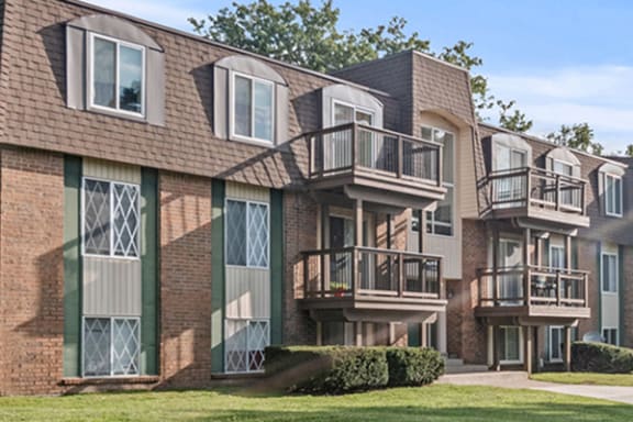 an apartment building with three balconies and a yard