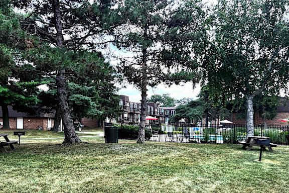 A green space with benchs and grills .