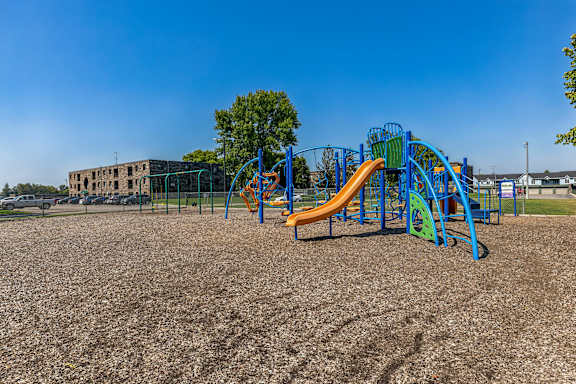 A playground with a blue and orange slide.