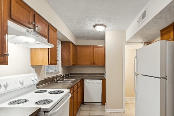 a kitchen with white appliances and wooden cabinets