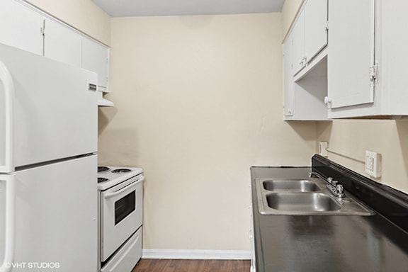 a kitchen with white appliances and a sink and a refrigerator