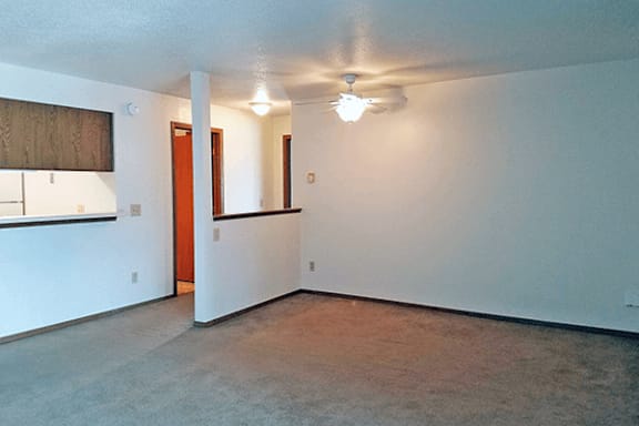 A room with a ceiling fan and a window with blinds.