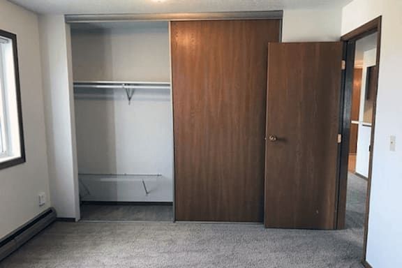 A room with a brown door and a white wall.