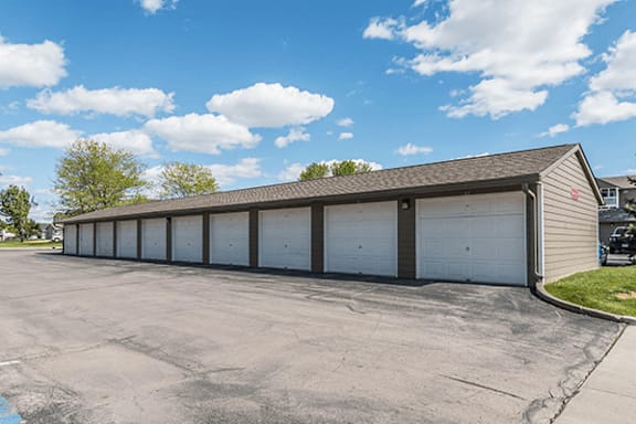 A long building with a grey roof and white garage doors.