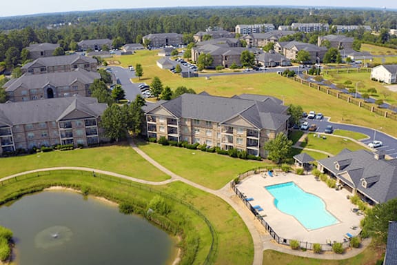 Aerial view of aparment grounds with pool and pond