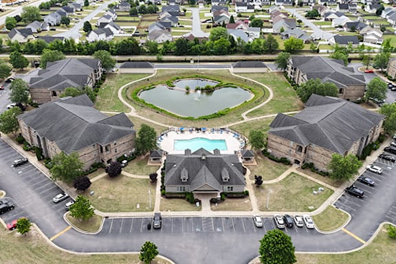 A bird's eye view of a neighborhood with houses and a pool and a parking.