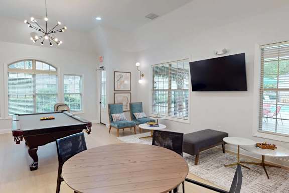 A room with a pool table and a television.