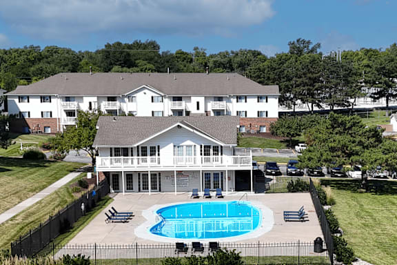 A large white house with a pool in the backyard.