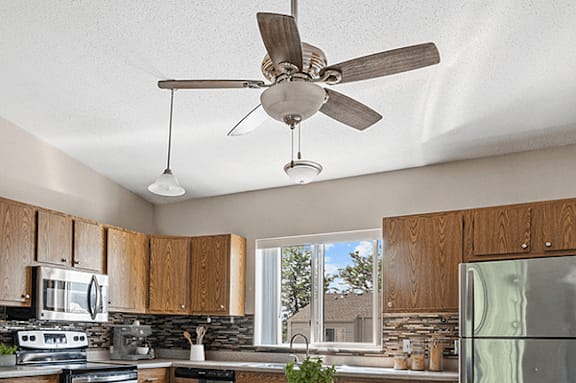 A kitchen with a fan hanging from the ceiling.