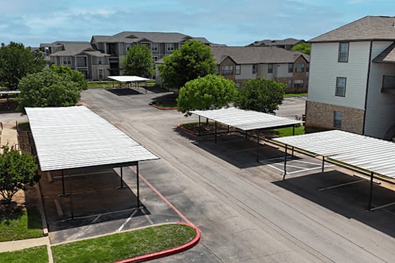 A parking lot with a few cars and a building in the background.