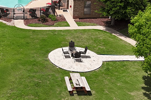 A picnic table is surrounded by a circular concrete patio.