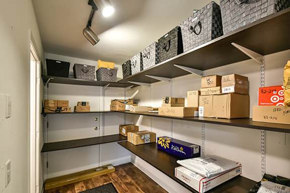 A storage room with boxes on shelves and a box on the floor.