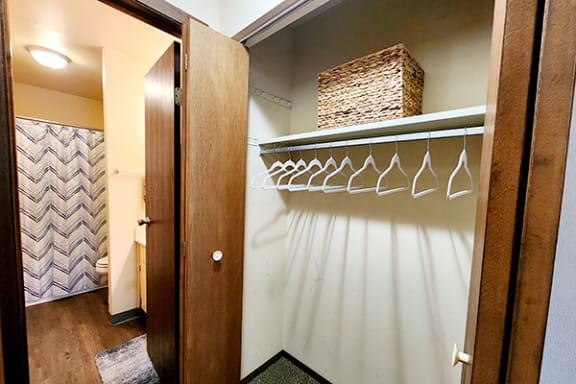 a walk in closet with a rack of wine glasses