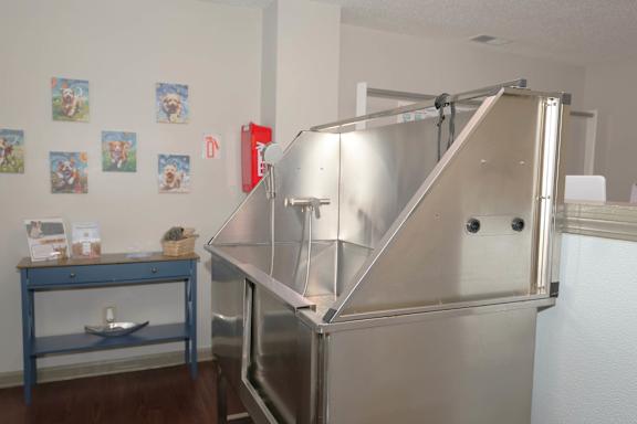 A large stainless steel refrigerator in a room with a blue table and pictures on the wall.
