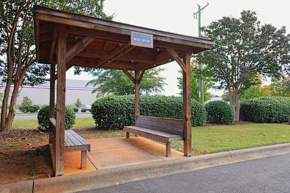 A bus stop shelter with a bench underneath it.