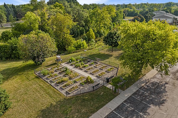 A cemetery with a lot of trees and a building in the background.
