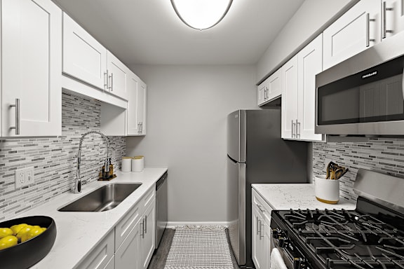 A kitchen with a black stove top oven and a black refrigerator.