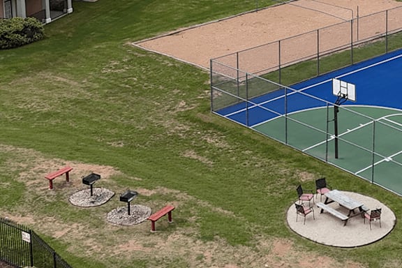 A basketball court with a blue surface and a white hoop.