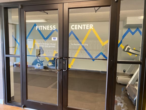 a fitness center with glass doors and a sign that says fitness center