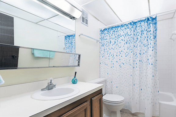 A white sink with a blue soap on top of it.