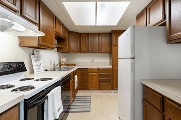 A kitchen with wooden cabinets and a white refrigerator.