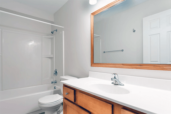 A white bathroom with a toilet, sink, and bathtub.