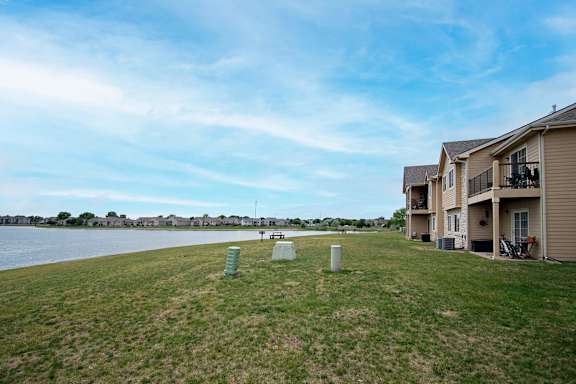 A grassy area with a few objects and apartment buildings in the background.