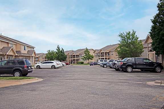 A parking lot with cars and apartment buildings in the background.