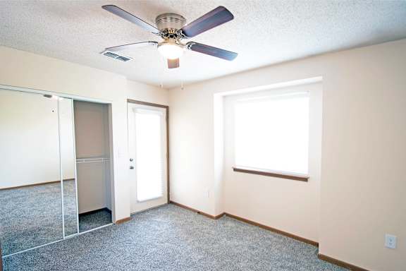 A room with a ceiling fan and a window.