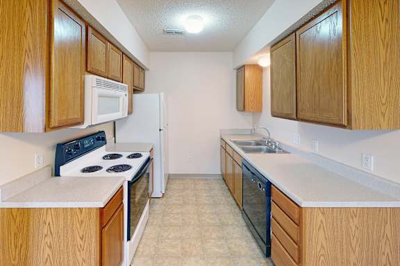 A kitchen with wooden cabinets and a white fridge.