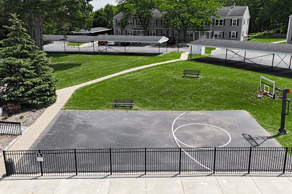 A basketball court is surrounded by a black fence.