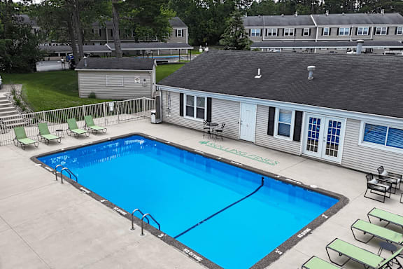 A small pool with a building behind it.