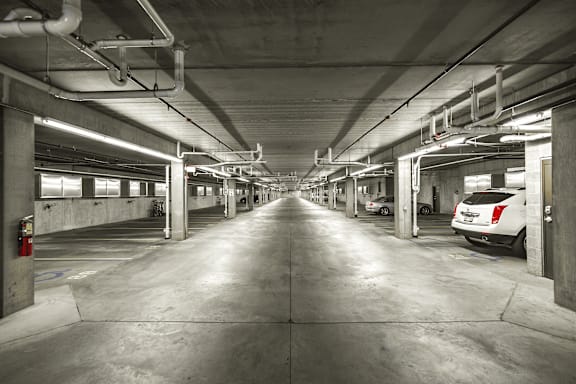 A long, narrow parking garage with concrete floors and walls.
